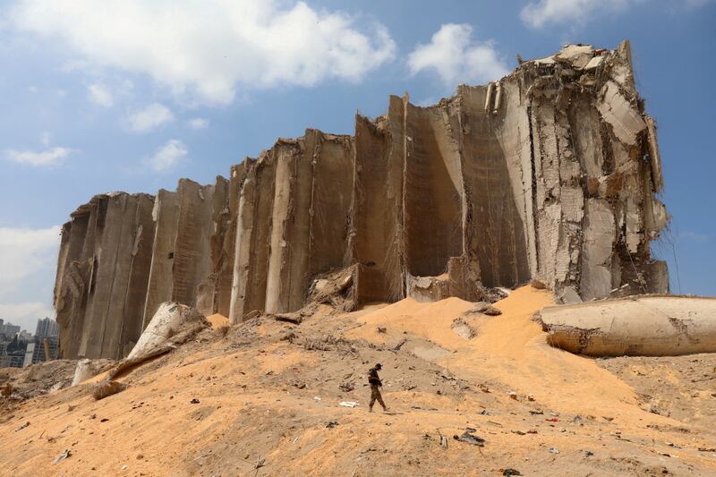 A Lebanese soldier walks past grain silos shattered by the blast at Beirut port in August 2020. Reuters