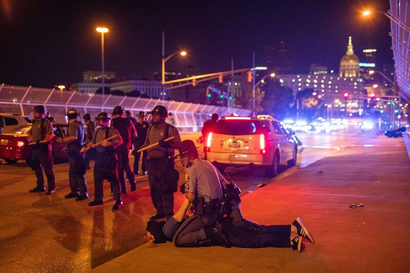 A protester is detained after a few dozen marchers walked on a bridge blocked by police in Atlanta, Georgia. Getty Images