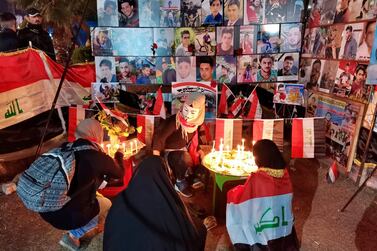 People light candles for slain protesters in Tahrir Square in Baghdad. ap