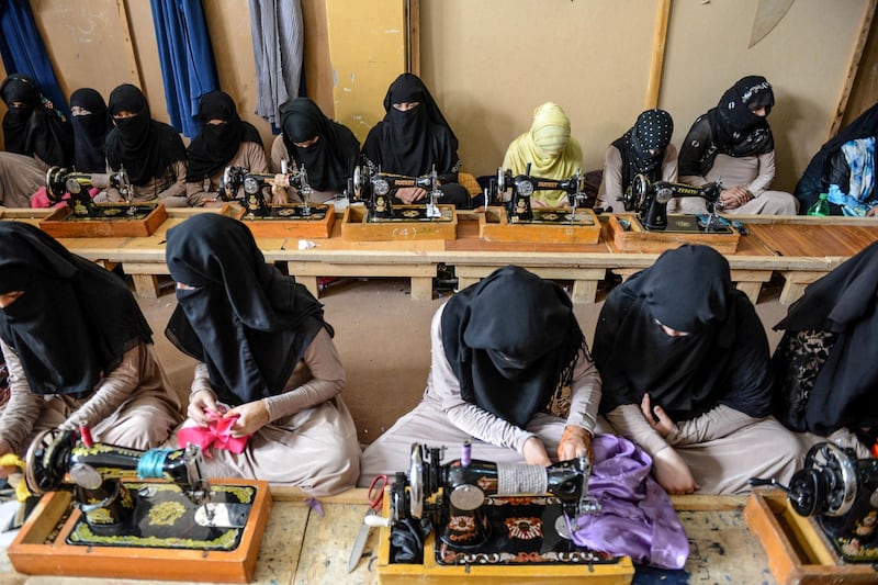 Labourers work with machines at a traditional sewing workshop in Kandahar city. AFP