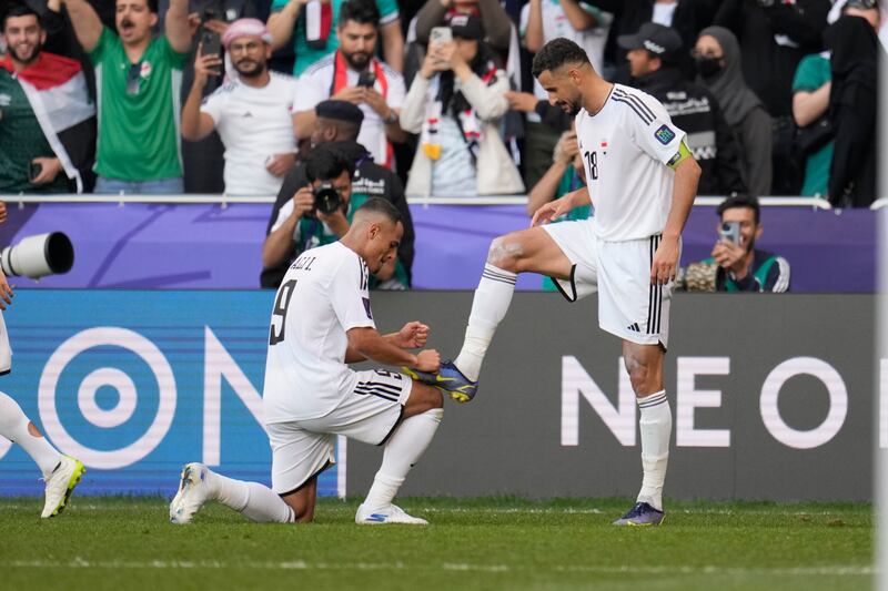 Iraq's Aymen Hussein, right, celebrates with Iraq's Ali Ibrahim Alzubaidi after scoring his side's third goal from the penalty spot. AP