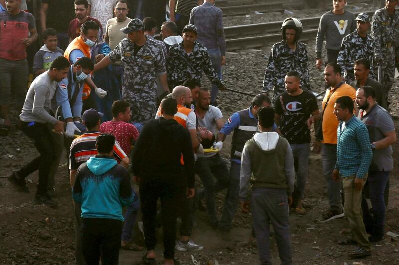 Medics carry an injured man at the site where a passenger train derailed injuring at least 100 people, in Banha, Qalyubia province, Egypt. AP Photo