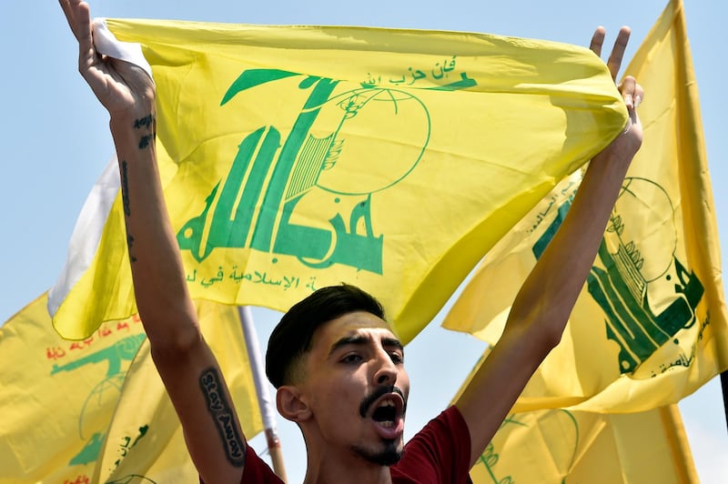 epa08534258 A supporter of Hezbollah carries his party flag during a protest against the visit of Commander of the US Army Central Command, Kenneth Franklin McKenzie to Lebanon at the highway of Rafic Hariri international airport in Beirut, Lebanon, 08 July 2020.  EPA/WAEL HAMZEH