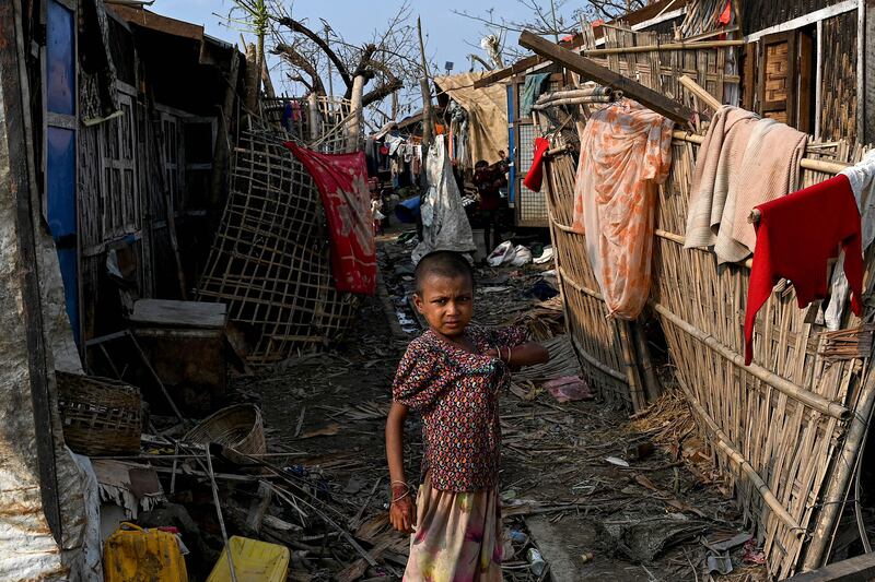 A girl stands next to her destroyed house at Ohn Taw Chay refugee camp in Sittwe, Myanmar, on May 16 after Cyclone Mocha. AFP