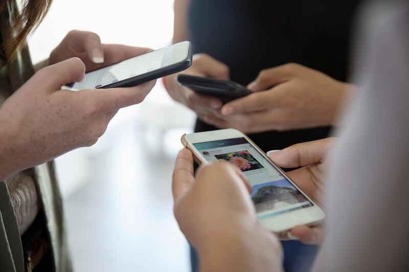 Close up teenage girl friends using cell phones