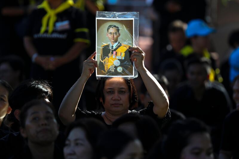A Thai woman holds up a portrait of late Thai King Bhumibol Adulyadej during a training exercise to pull a royal funeral chariot vehicle, which will be used in the procession for the royal funeral pyre of the late Thai King Bhumibol Adulyadej's cremation ceremony, in the area of the Grand Palace in Bangkok, Thailand. Diego Azubel / EPA