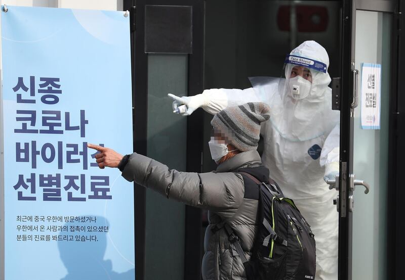 A citizen receives directions from a quarantine official at the National Medical Centre, where the 13th patient infected with the novel coronavirus is being treated, in Seoul, South Korea.  EPA