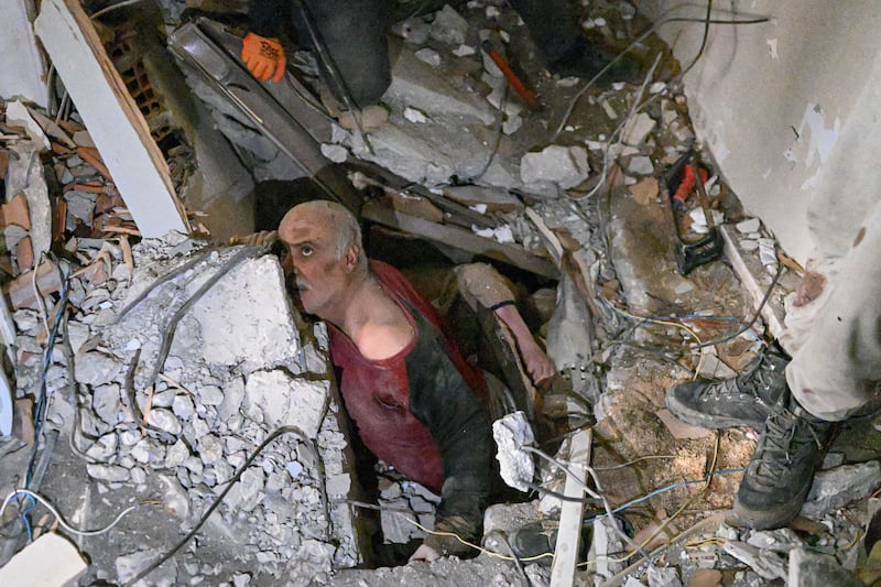 A man trapped in rubble waits while debris is removed in Hatay. AFP