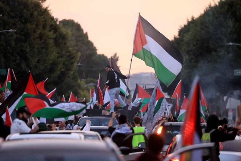 Protesters wave Palestinian flags at a rally in LA. AFP