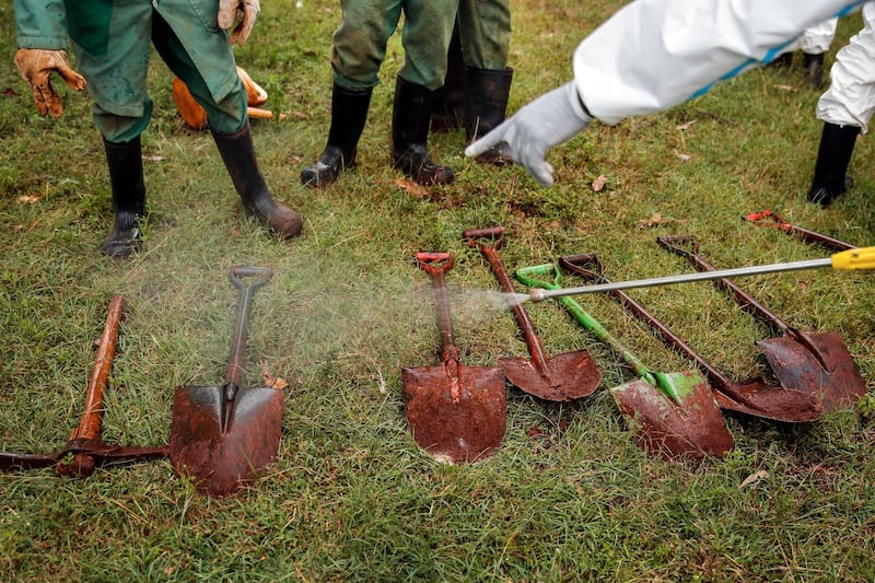 Members of a team dedicated to burying Muslim victims of the new coronavirus disinfect their tools at the Langata Muslim cemetery, in Nairobi, Kenya. AP Photo