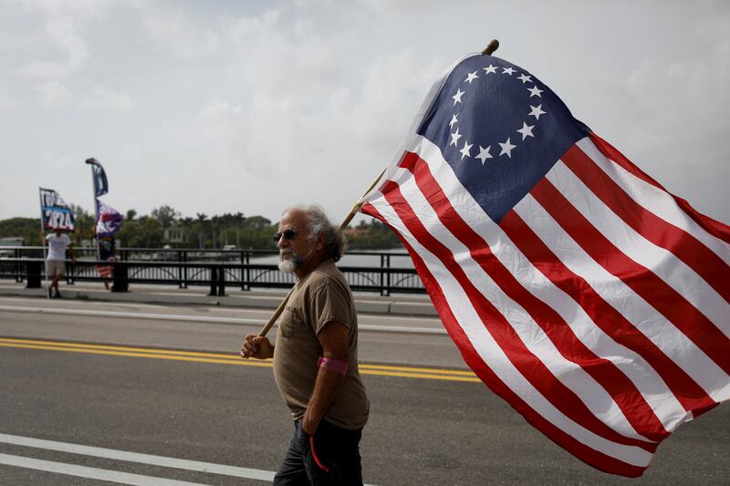 A Trump supporter holds the Betsy Ross flag at a gathering outside the former president's Mar-a-Lago home. Reuters