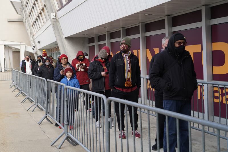 Fans wait in freezing temperatures for the gift shop to open at Fedex Stadium. Willy Lowry / The National.