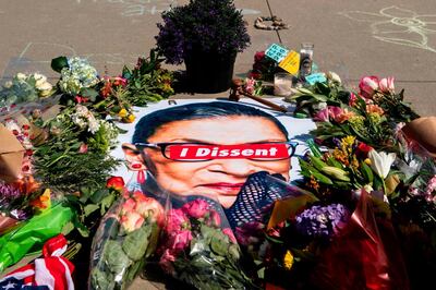 A banner with flowers are pictured at a makeshift memorial outside of the US Supreme Court as people pay their respects to Ruth Bader Ginsburg in Washington, DC on September 19, 2020. US President Donald Trump vowed to quickly nominate a successor, likely a woman, to replace late Supreme Court Justice Ruth Bader Ginsburg, only a day after the death of the liberal stalwart. / AFP / Jose Luis Magana
