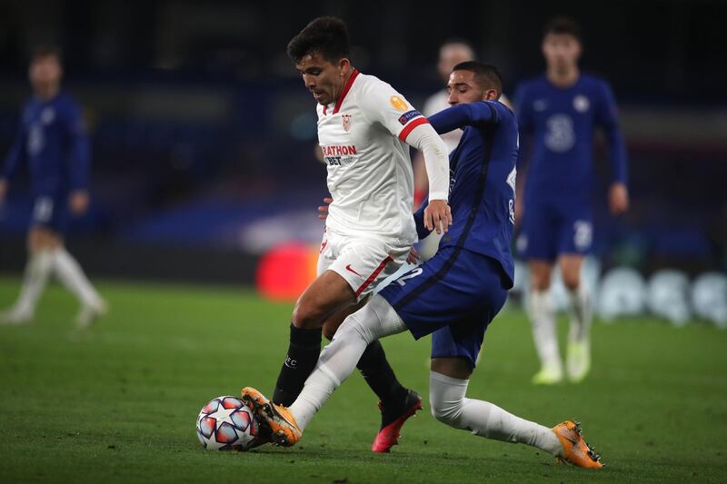 Sevilla midfielder Marcos Acuna is challenged by Hakim Ziyech. AFP