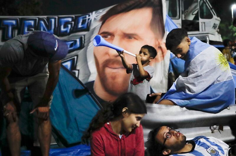 Fans in front of a banner of Lionel Messi. Getty Images