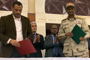 Mohamed Hamdan Dagalo, right, and protest movement Alliance for Freedom and Changes leader Ahmad Al Rabiah stand after inking an agreement before African Union and Ethiopian mediators in Khartoum, Sudan. AFP