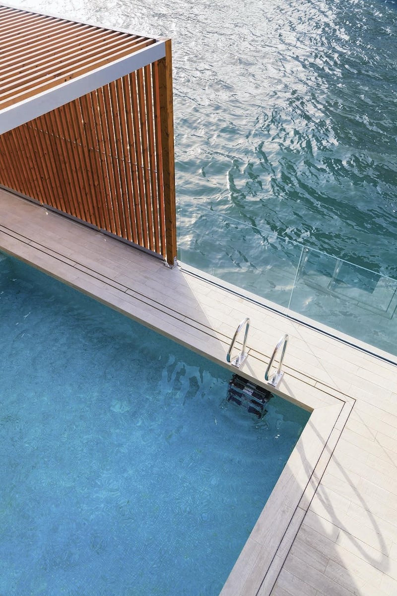 The pool is separated from the canal by a low-hanging glass wall