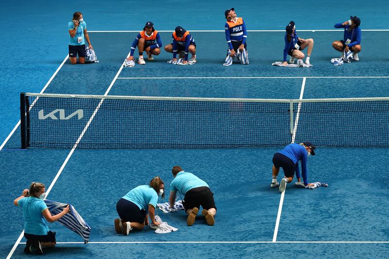 Ball kids dry the court after rain interrupted the Men's Singles Quarterfinals match between Stefanos Tsitsipas of Greece and Jannik Sinner of Italy during day 10 of the 2022 Australian Open at Melbourne Park in Australia. Getty Images