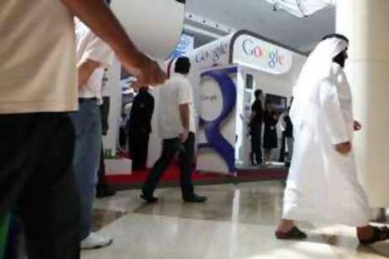 DUBAI, UNITED ARAB EMIRATES - OCTOBER 20:  People walk by the  Google stand on the second day of GITEX Technology Week, which was held at the Dubai International Convention and Exhibition Centre in Dubai on October 20, 2008.  (Randi Sokoloff / The National)  To go with story by Tom Gara. *** Local Caption ***  RS021-1020-GITEX.jpg
