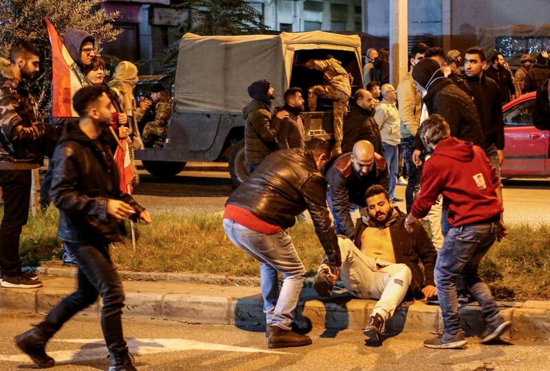 People help a wounded protester during clashes in central Beirut. EPA