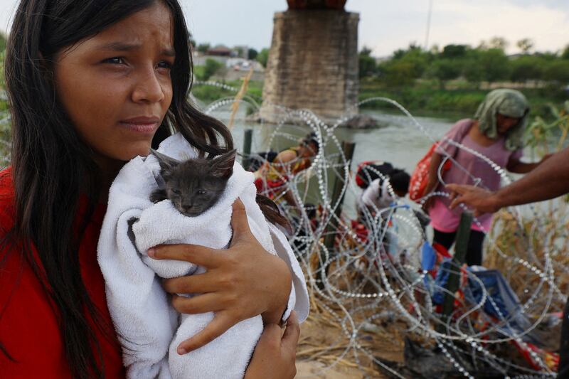 A migrant from Venezuela holds a cat she picked up along the way, after crossing the Rio Grande. Reuters