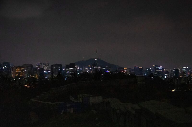 The YTN Seoul Tower and the historic Seoul Fortress Wall are seen after their lights went out for the Earth Hour in Seoul. AFP