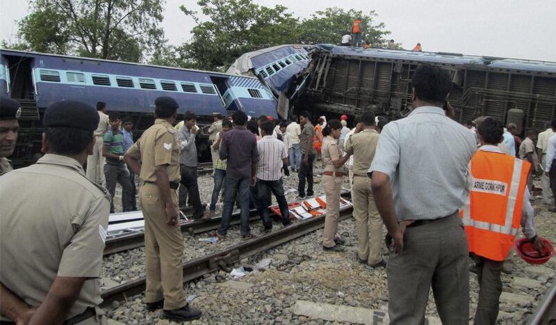 Rescuers stand near the wreckage after the Gorakhpur Express passenger train which slammed into a parked freight train near Basti, Uttar Pradesh state in India on May 26, 2014, killing at least 40 people. AP Photo