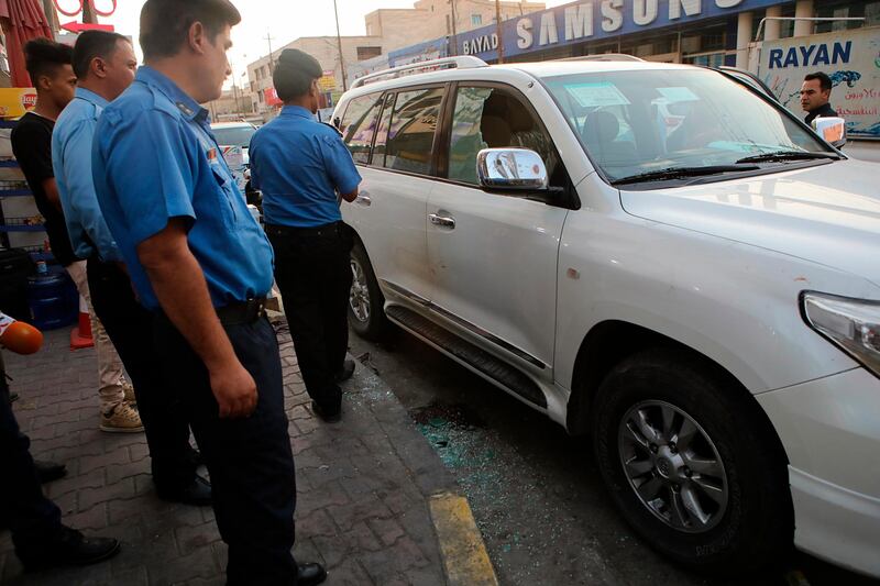 Security forces investigate a vehicle at the site of the assassination of Soad al-Ali, who has been involved in organizing protests demanding better services in the city, in the southern city of Basra, Iraq, Tuesday, Sept. 25, 2018. A police official said masked gunmen shot dead al-Ali, a mother of four, outside a supermarket. The gunmen fled the scene after shooting at her and her husband in their car. (AP Photo/Nabil al-Jurani)