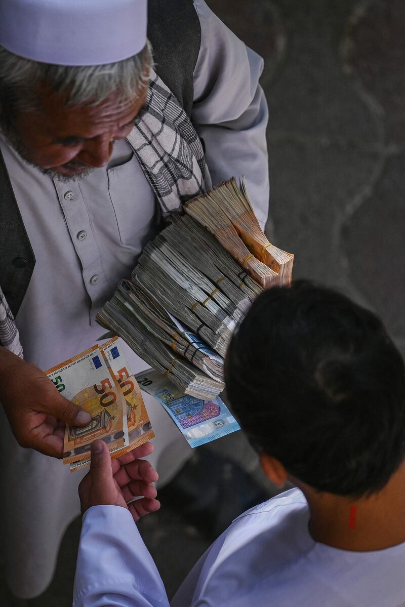 Foreign currency dealers transact in Kabul. AFP