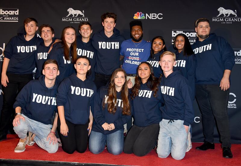 Shawn Mendes, fifth from left, and Khalid, forth from right, pose in the press room with the Stoneman Douglas choir, of the Marjory Stoneman Douglas High School at the Billboard Music Awards. AP