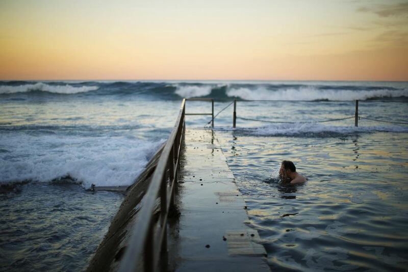 A swimmer splashes his face in between laps at a pool as the waves of the Pacific Ocean roll in during twilight at Sydney's South Cronulla Beach. Despite the sun setting earlier with a southern hemisphere winter approaching, Sydneysiders continue to take advantage of mild sea temperatures into May. Jason Reed / Reuters