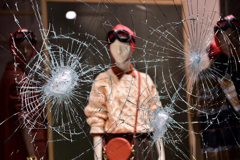 A damaged window of a store is seen as people protest against the new restrictions introduced by the government to curb the coronavirus disease infections, in Turin, Italy. REUTERS