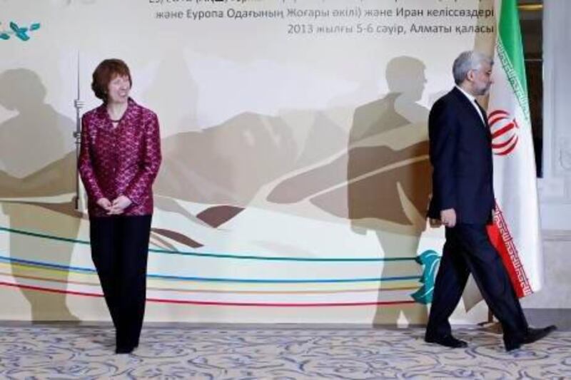 EU foreign policy chief Catherine Ashton, left, smiles, as Iran's chief negotiator Saeed Jalili walks away at a start of high-level talks between world powers and Iranian officials in Almaty on Friday. Shamil Zhumatov / AP Photo