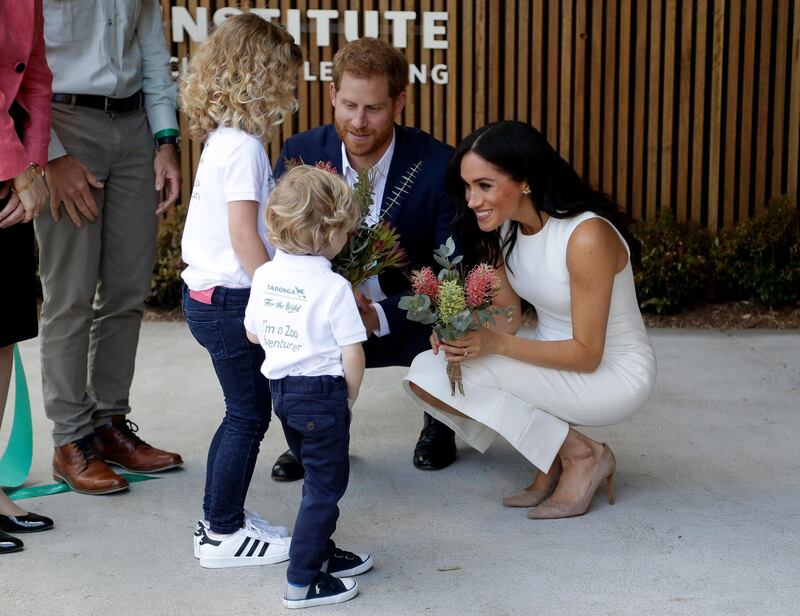 SYDNEY, AUSTRALIA - OCTOBER 16:  Prince Harry, Duke of Sussex and Meghan, Duchess of Sussex are presented with native flowers from children, Dasha Gallagher (L) and Finley Blue, during a ceremony at Taronga Zoo on October 16, 2018 in Sydney, Australia. The Duke and Duchess of Sussex are on their official 16-day Autumn tour visiting cities in Australia, Fiji, Tonga and New Zealand.  (Photo by Kristy Wigglesworth ‚Äì Pool/Getty Images)