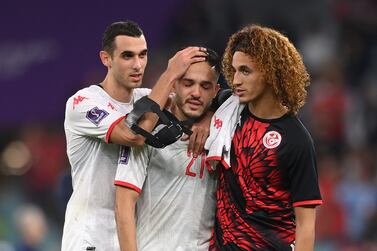 AL RAYYAN, QATAR - NOVEMBER 30: Wajdi Kechrida of Tunisia (c) is consoled by team mates Ellyes Skhiri (l) and Hannibal Mejbri after the FIFA World Cup Qatar 2022 Group D match between Tunisia and France at Education City Stadium on November 30, 2022 in Al Rayyan, Qatar. (Photo by Stu Forster / Getty Images)