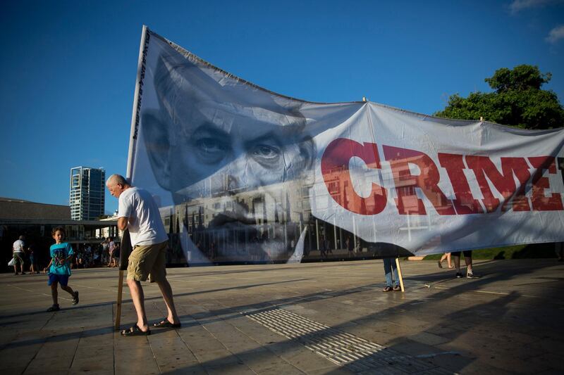 Israelis carry a banner showing Israeli Prime Minister Benjamin Netanyahu during a protest against the Israel Jewish nation bill, in Tel Aviv, Israel, Monday, July 30, 2018. Last week Israel's parliament approved a controversial piece of legislation that defines the country as the nation-state of the Jewish people. Opponents and rights groups have criticized the legislation, warning that it will sideline minorities such as the country's Arabs. (AP Photo/Oded Balilty)