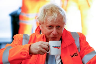 Britain's Prime Minister Boris Johnson holds a mug during a visit to a construction site in Manchester on October 4, 2021 on the sidelines of the annual Conservative Party Conference.  (Photo by PHIL NOBLE  /  POOL  /  AFP)
