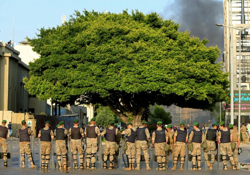 Smoke rises as Lebanese Army soldiers stand guard during a protest against the government performance and worsening economic conditions, in Beirut, Lebanon June.  REUTERS