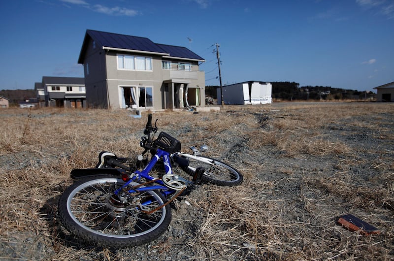 FILE PHOTO: An abandoned child's bicycle and houses destroyed by the tsunami are seen in Tomioka town, inside the exclusion zone of a 20km radius around the crippled Fukushima Daiichi nuclear power plant, Fukushima prefecture, January 15, 2012. REUTERS/Issei Kato/File Photo