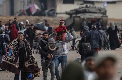 Palestinians move past Israeli tanks and head towards Rafah camps near the Egyptian border. EPA