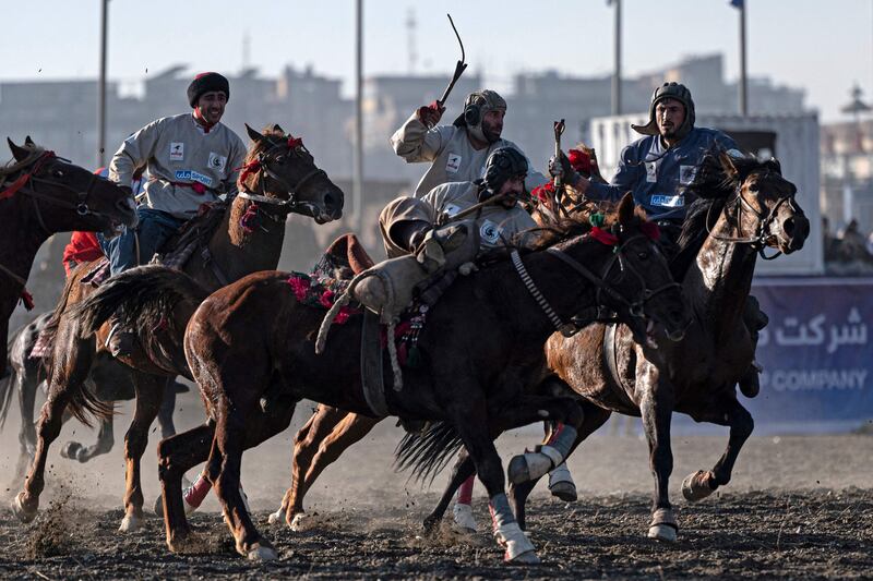 Afghan horsemen from the Baghlan (in blue) and Sar-e Pol teams compete during the fifth Buzkashi League in Kabul. AFP