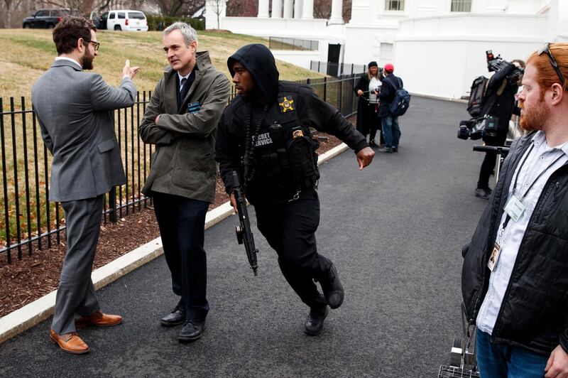 A Secret Service officer rushes past reporters after a vehicle rammed into a security barrier near the White House, Friday, Feb. 23, 2018, in Washington. (AP Photo/Evan Vucci)