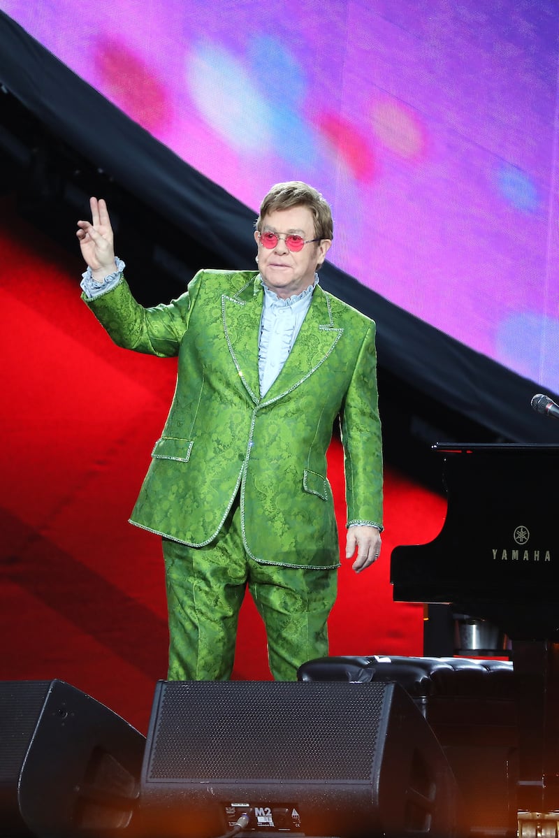 Elton John, in a green brocade suit, performs on stage during Global Citizen Live on September 25, 2021 in Paris, France. Getty Images