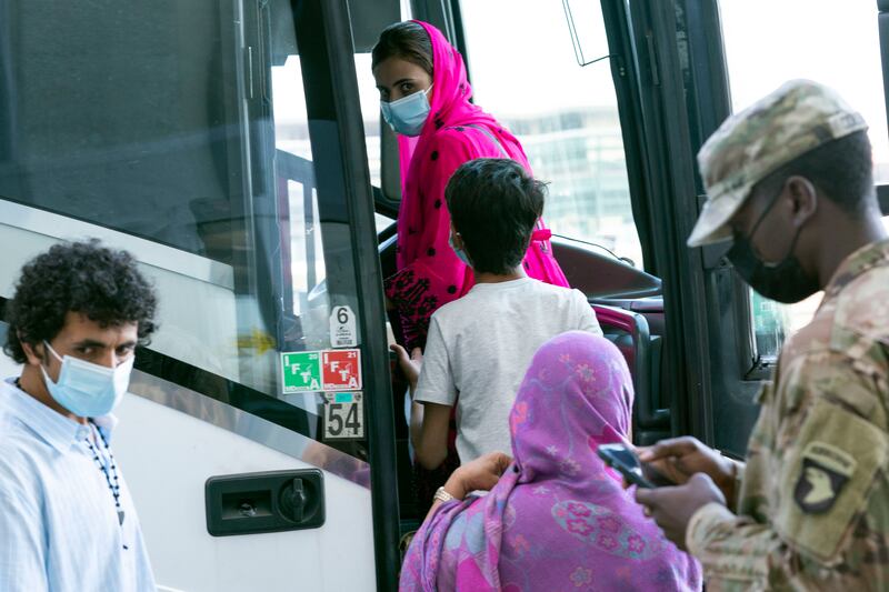 People who fled the Taliban in Afghanistan board a bus outside Washington Dulles International Airport in the US. AP