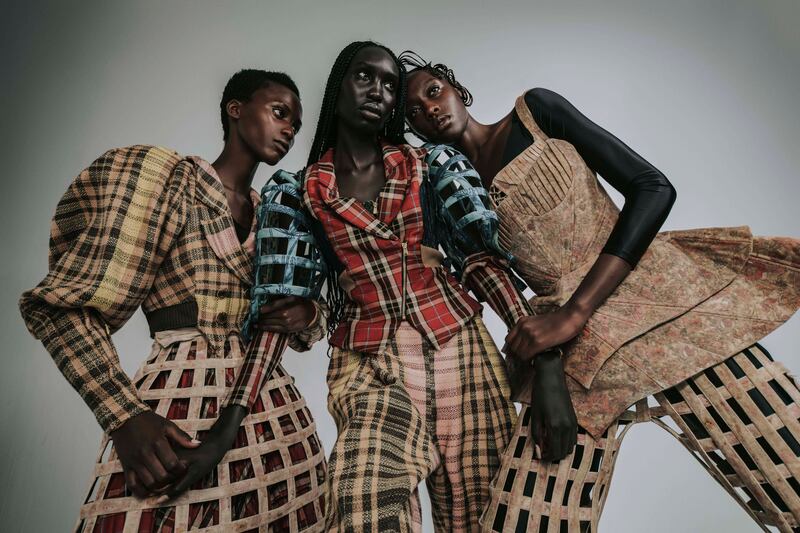 From left, Kristine in a woven raffia double breasted jacket, mini crinoline and kilt; Nyajouk in a tartan and denim jacket with caged sleeves and woven raffia trousers; Mitchell in a corset with straps over a skirt and crinoline trousers; all from Taruni Kottakota