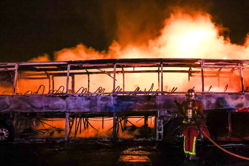 Firefighters control the blaze on a burning bus in Nanterre. EPA