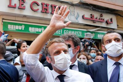 (FILES) In this file photo taken on August 06, 2020, French President Emmanuel Macron (C) waves in front of Beirut's landmark traditional restaurant Le Chef during his tour of the Lebanese capital's heavily-damaged Gemmayzeh neighbourhood on August 6, 2020, two days after a the massive port explosion which devastated the city in a disaster that has sparked grief and fury across the world.  Hollywood star Russell Crowe said on August 13, 2020 that he donated funds to help rebuild a blast-hit Beirut restaurant on behalf of late food icon Anthony Bourdain, who loved its traditional dishes. The decades-old Le Chef restaurant, located in the heart of a trendy Beirut district, is a beloved neighbourhood place renowned for its home-style cooking.  / AFP / POOL / Thibault Camus
