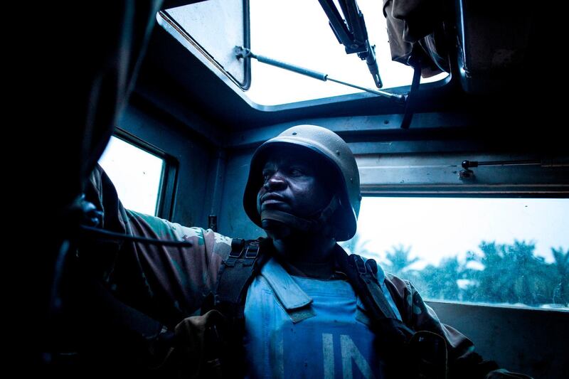 TOPSHOT - A South African soldier from the United Nations Stabilisation Mission in the Democratic Republic of the Congo (MONUSCO) is seen in the back of a armoured personal carrier on October 05, 2018 in Oicha.  The town of Oicha is the site of constant attacks by the Allied Democratic Front (ADF) rebel group. MONUSCO soldiers are sent to help the Armed Forces of the Democratic republic of the Congo(FARDC) in the fight against ADF. / AFP / JOHN WESSELS
