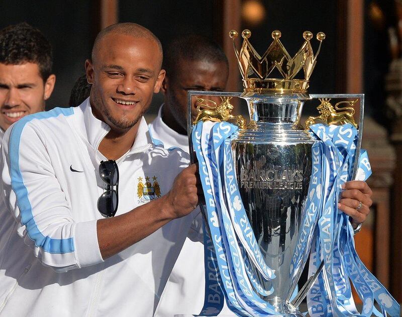 Vincent Kompany poses with the Premier League trophy at Manchester City's title parade in Manchester on Monday. Paul Ellis / AFP / May 12, 2014  