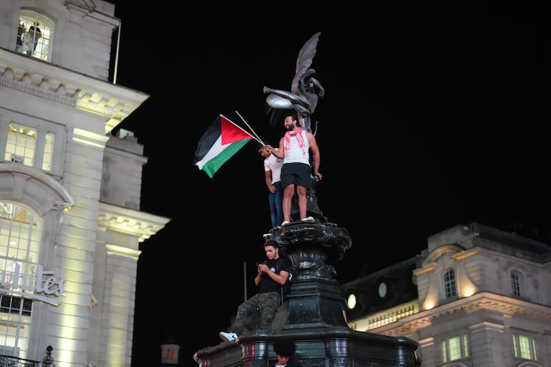 Pro-Palestinian demonstrators climb the statue of Eros in Piccadilly Circus, London. Getty Images